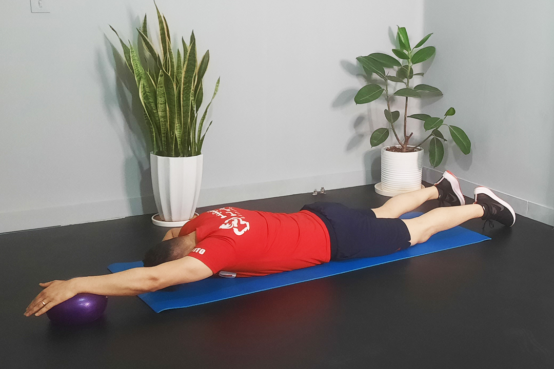 رول کردن بالا تنه با خم کردن پا روی توپ دمر